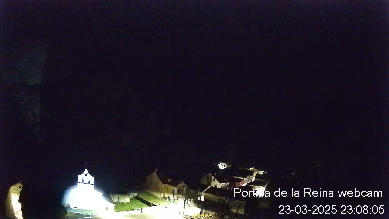 A nighttime, aerial view of a small town illuminated by artificial light under a dark sky.