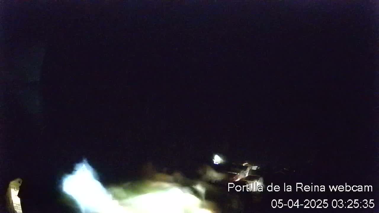 A nighttime, low-light view shows indistinct shapes and bright lights in the lower portion of the frame against a completely dark sky.