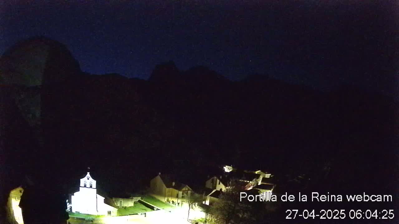 A small village nestled in a dark valley under a clear, starlit night sky.