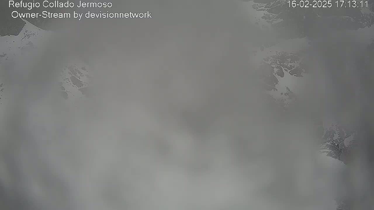 A blurry, foggy view of a snow-covered mountain landscape.
