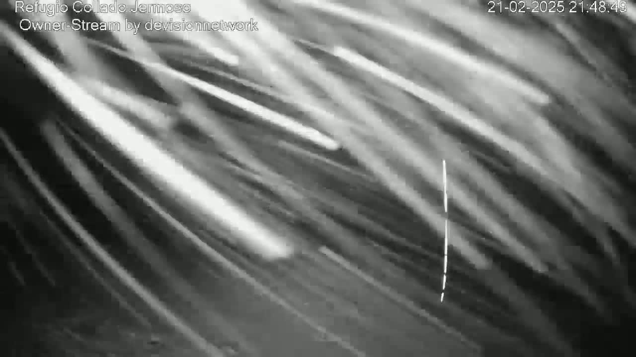 A blurry, grayscale image shows streaks of light suggesting motion, possibly a nighttime, long-exposure shot of a cloudy sky.