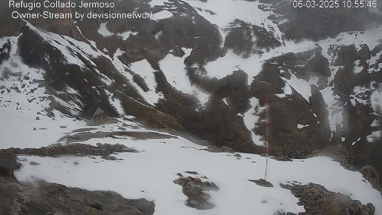 A high-angle view of a snow-covered mountain range on an overcast day.