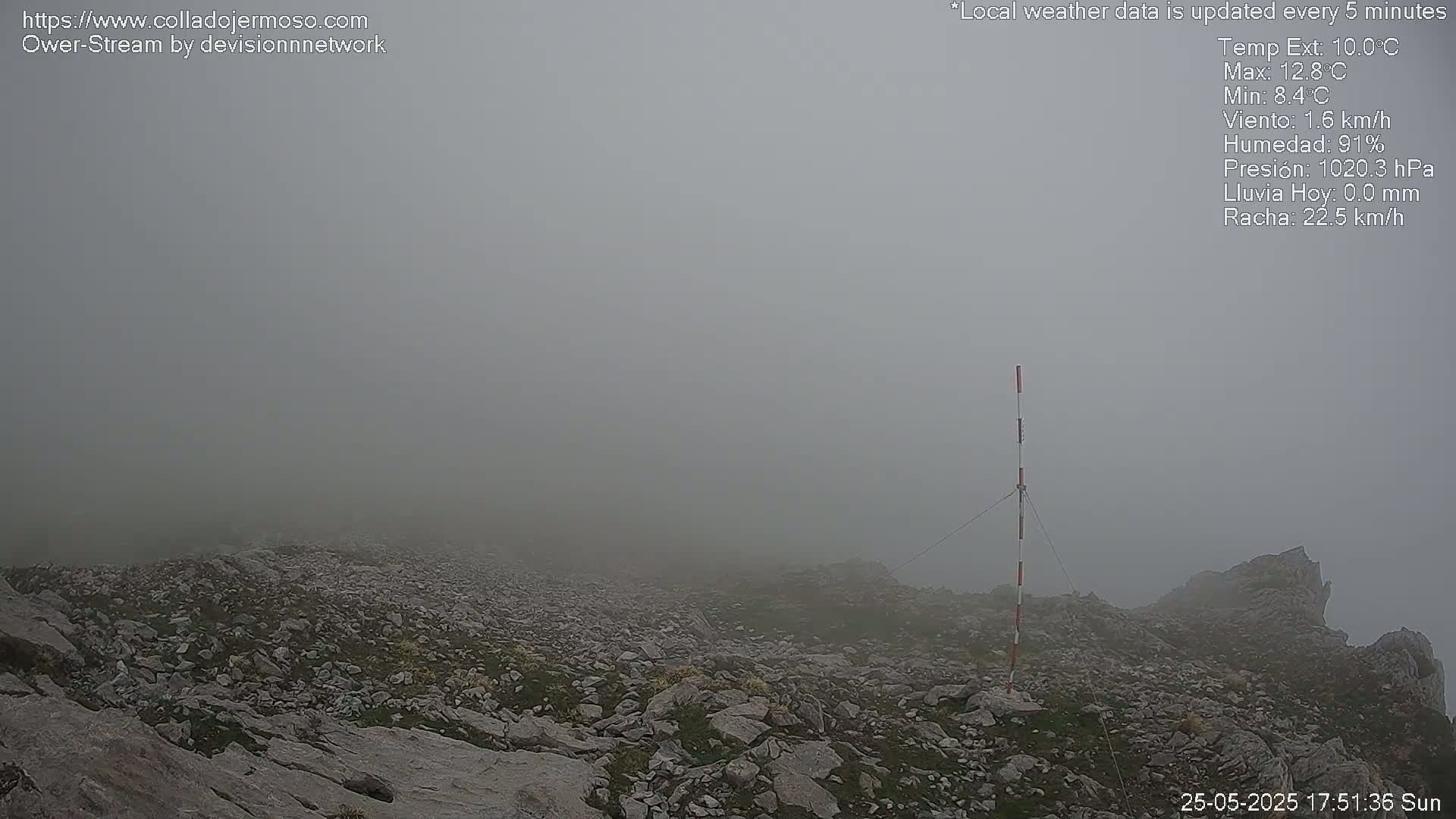 A rocky, fog-shrouded mountaintop is visible, with a tall pole standing near the foreground.