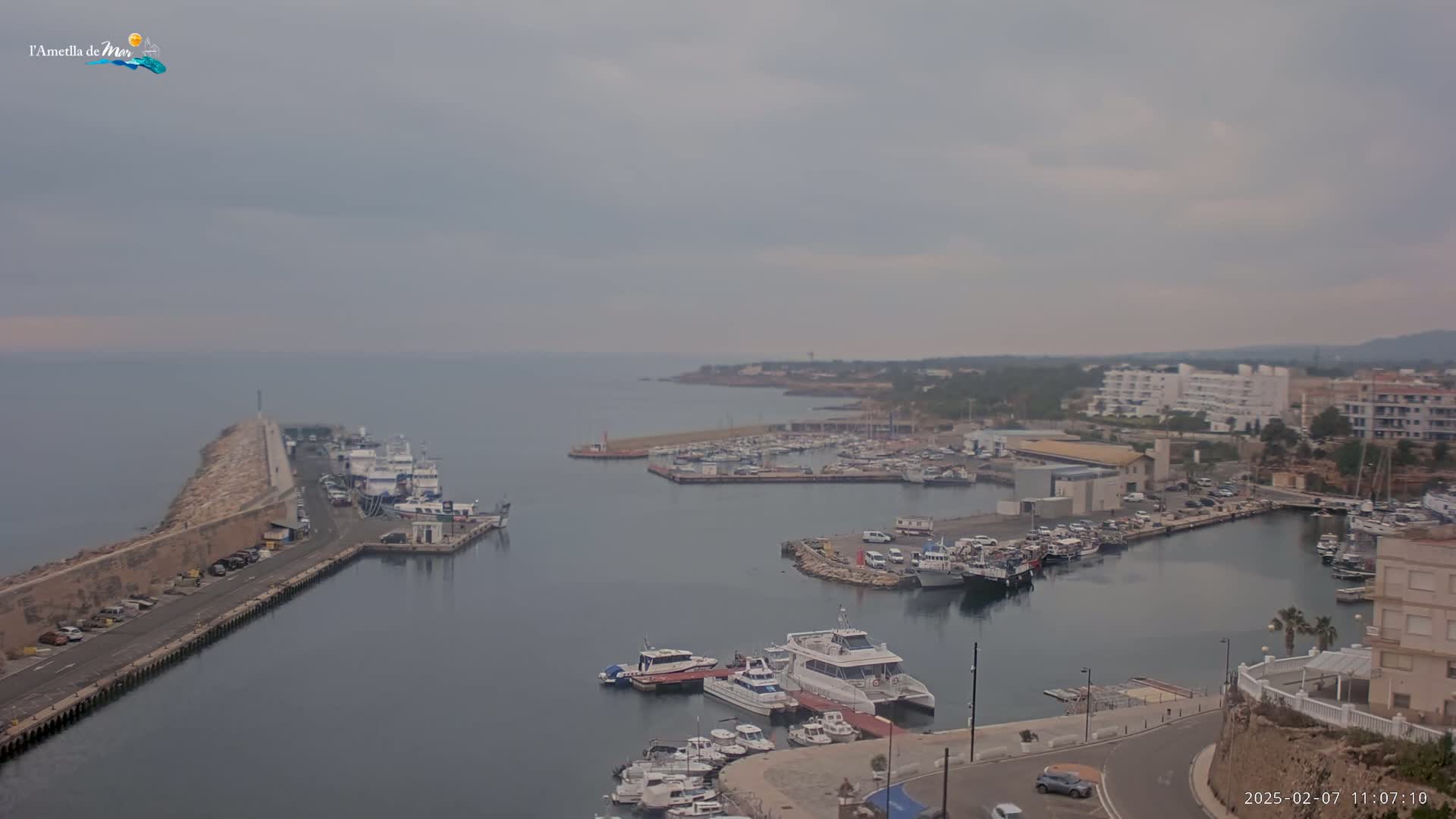 A harbor filled with numerous boats and yachts is shown under an overcast sky.