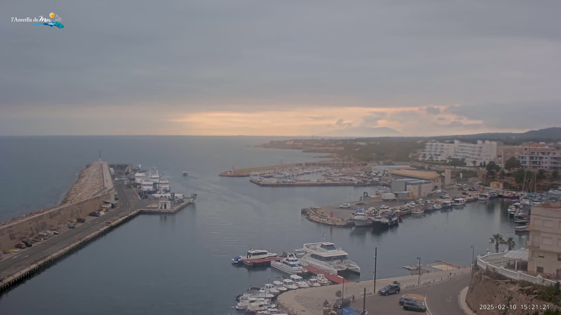 A harbor filled with numerous boats and buildings is seen under an overcast sky.
