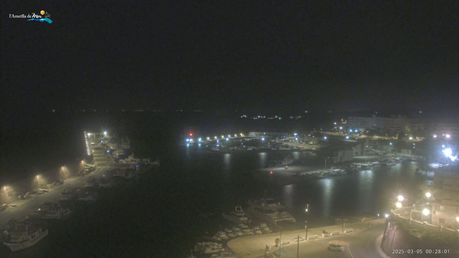 A nighttime, high-angle view of a harbor filled with boats, surrounded by dimly lit buildings and streets.