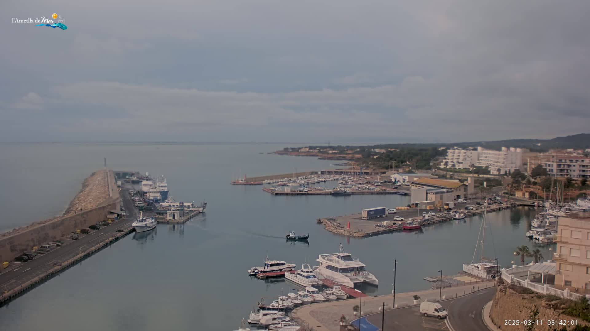 A harbor filled with numerous boats and yachts under a mostly cloudy sky.