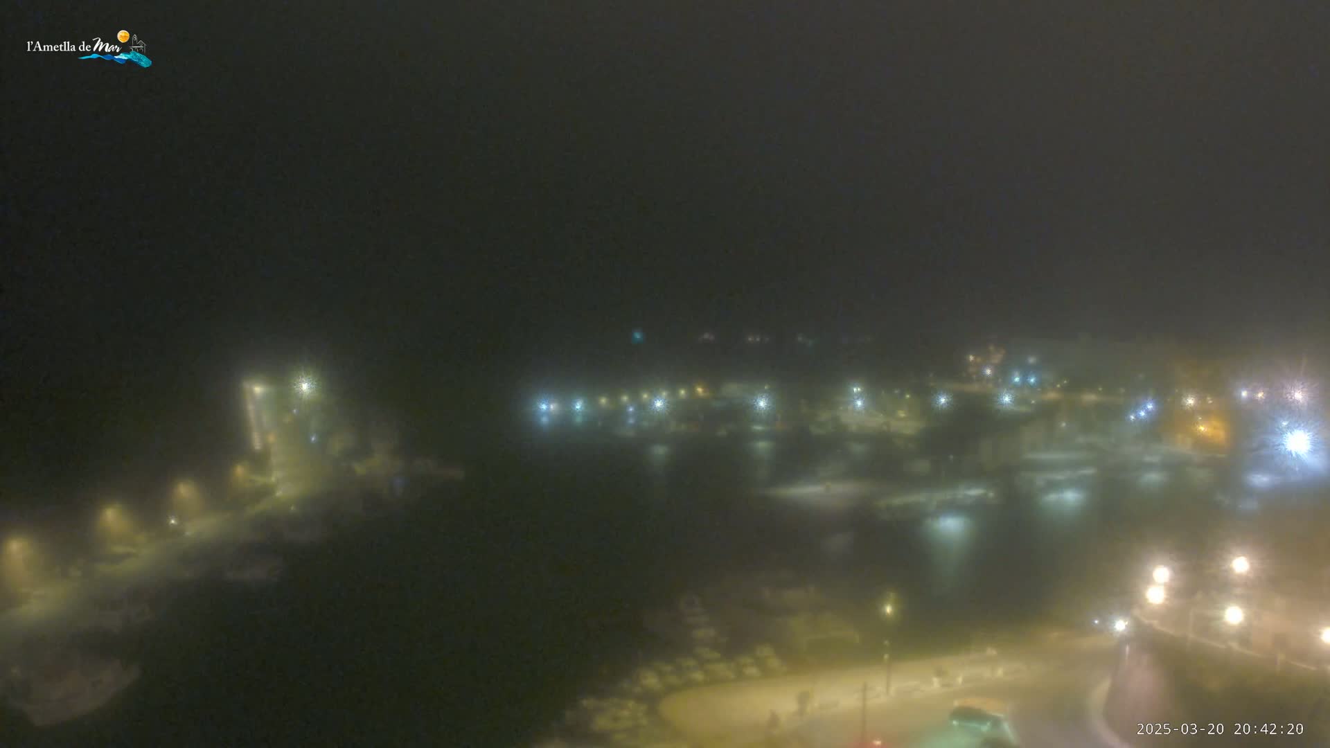 A foggy night scene shows a harbor with dimly lit buildings and boats, and a roadway along the waterfront.
