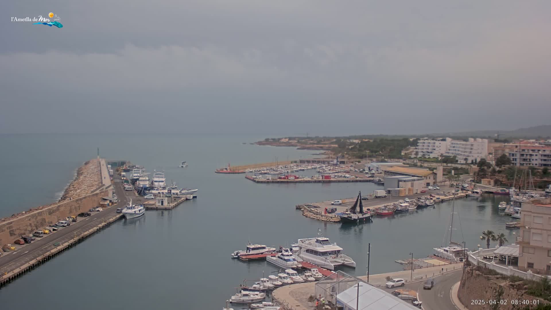 A harbor filled with boats is shown on an overcast day.