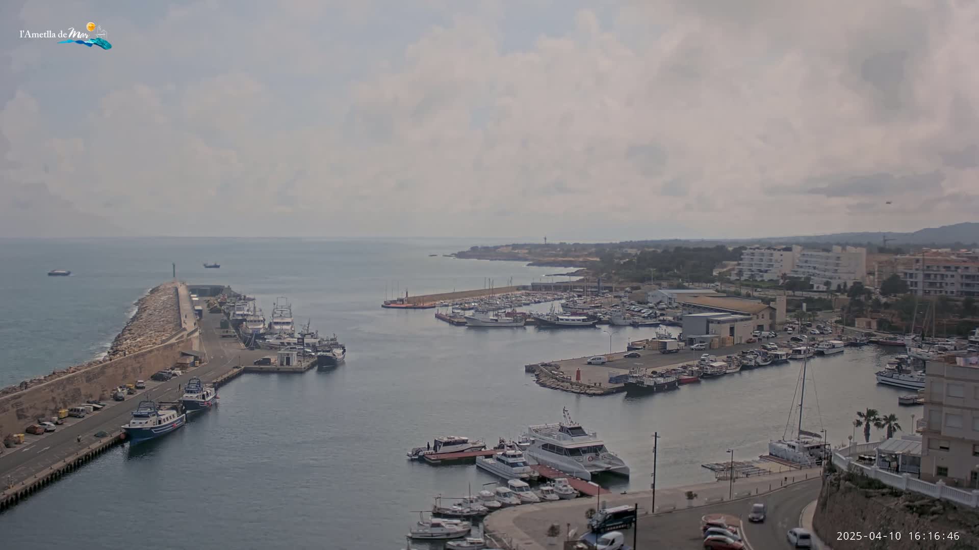A harbor filled with numerous boats and yachts under a cloudy sky.
