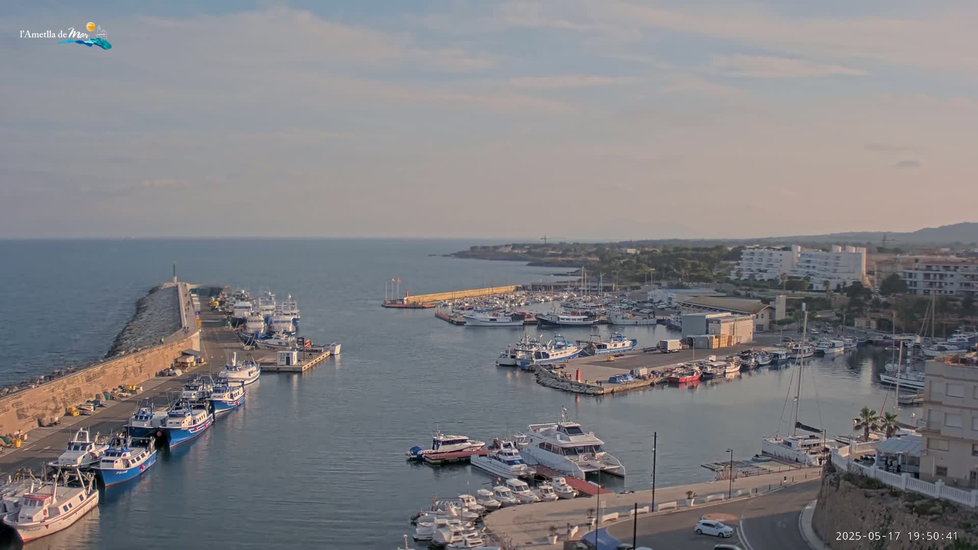 A harbor filled with numerous boats and yachts under a partly cloudy sky.