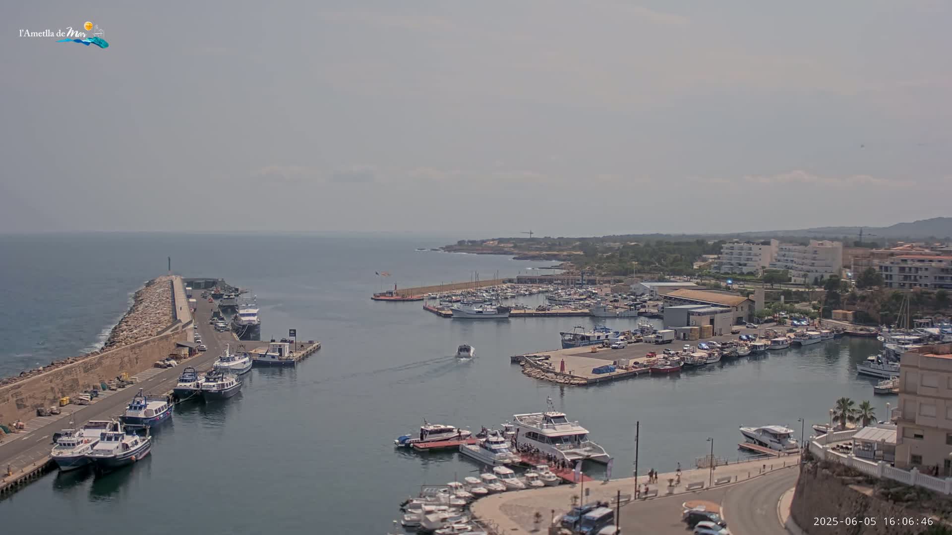 A harbor filled with numerous boats and yachts on a hazy, sunny day.