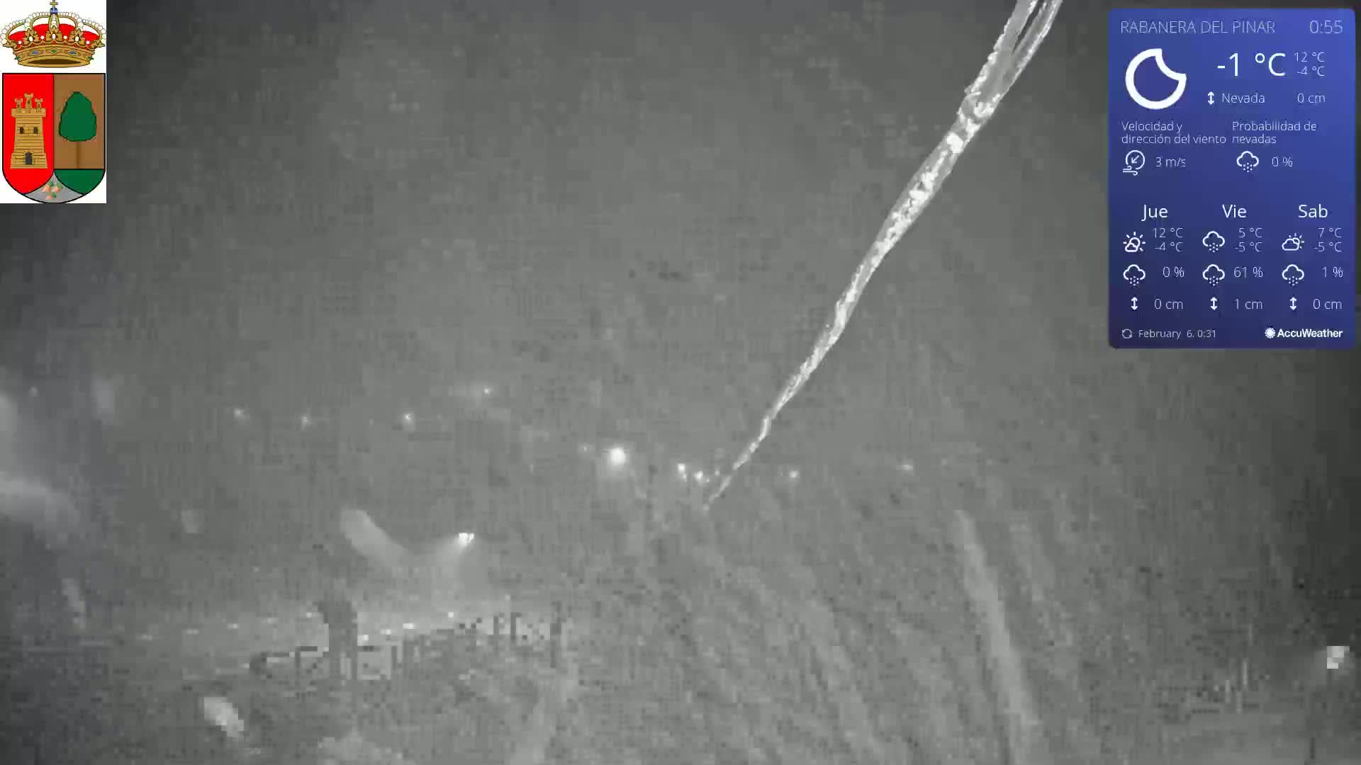 A nighttime scene of snowy conditions shows a roadway with faint streetlights, and a large icicle forming on a structure in the foreground.