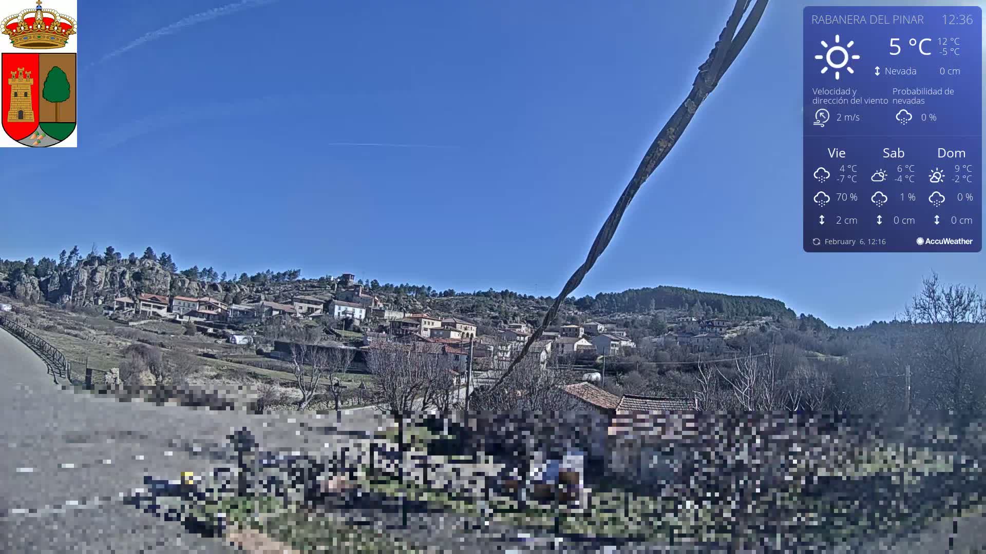 A small village nestled in a rocky hillside under a clear blue sky.