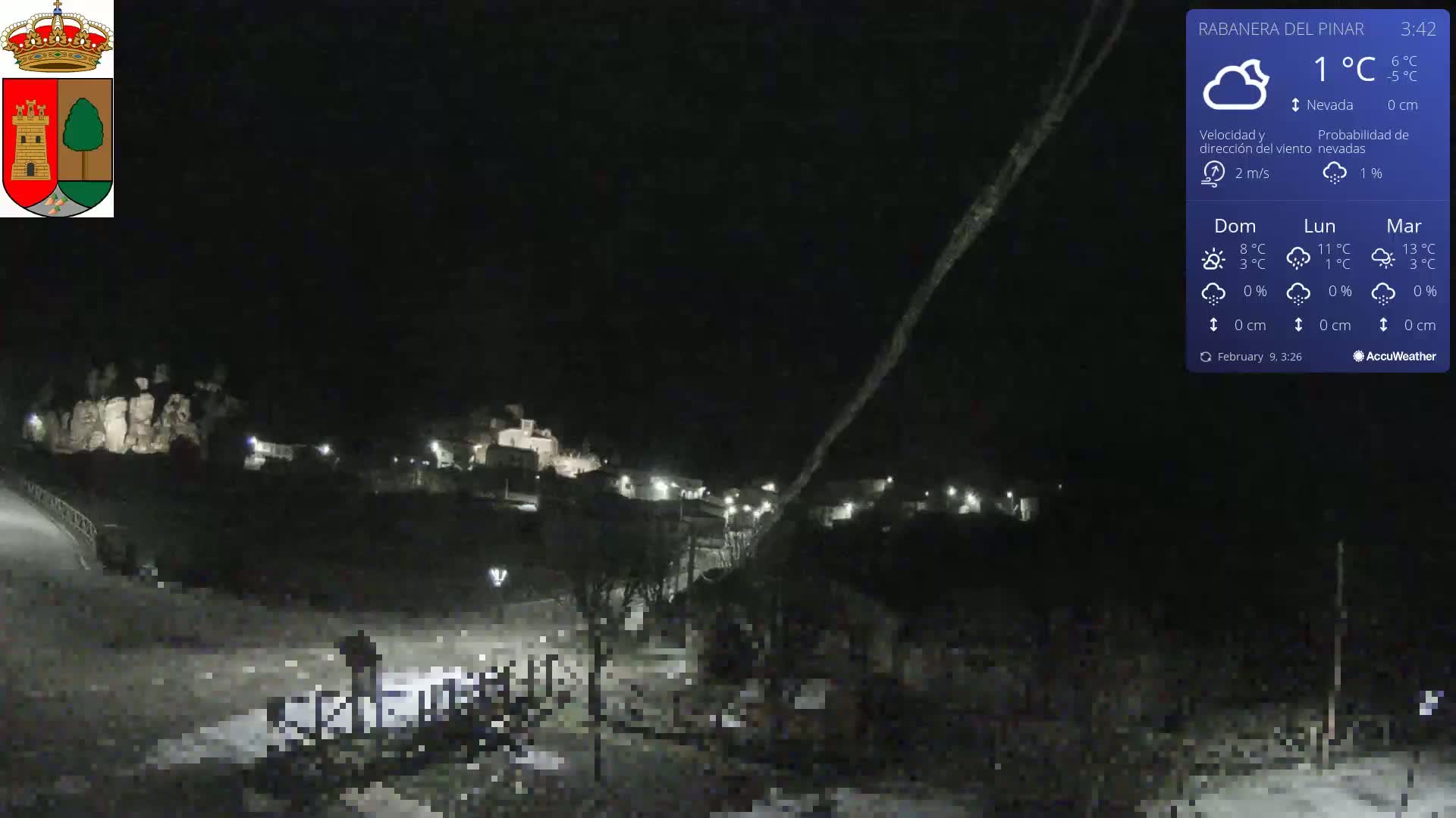 A nighttime view of a small town under a mostly clear sky with a temperature of 1°C and light winds.