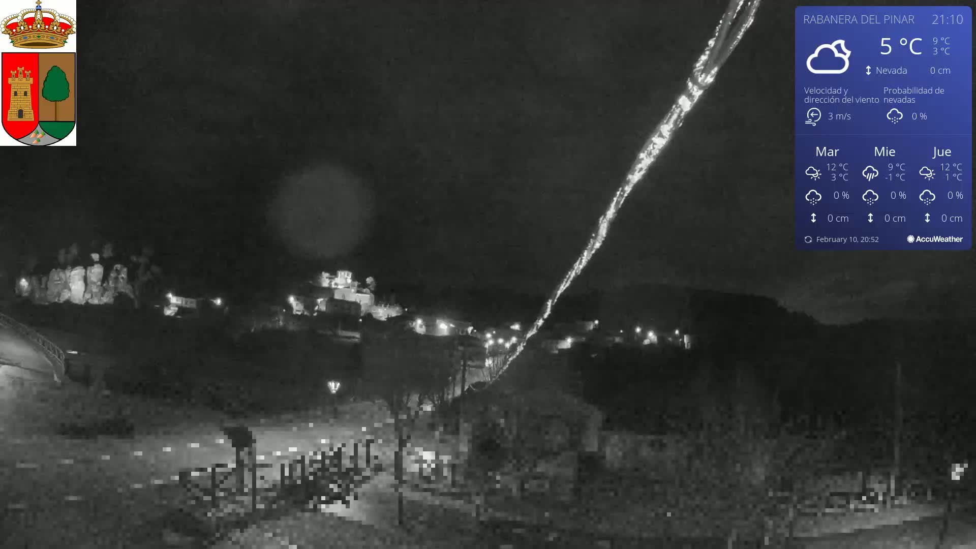 A nighttime, low-light view of a town illuminated sparsely, under a cloudy sky with a temperature of 5°C.