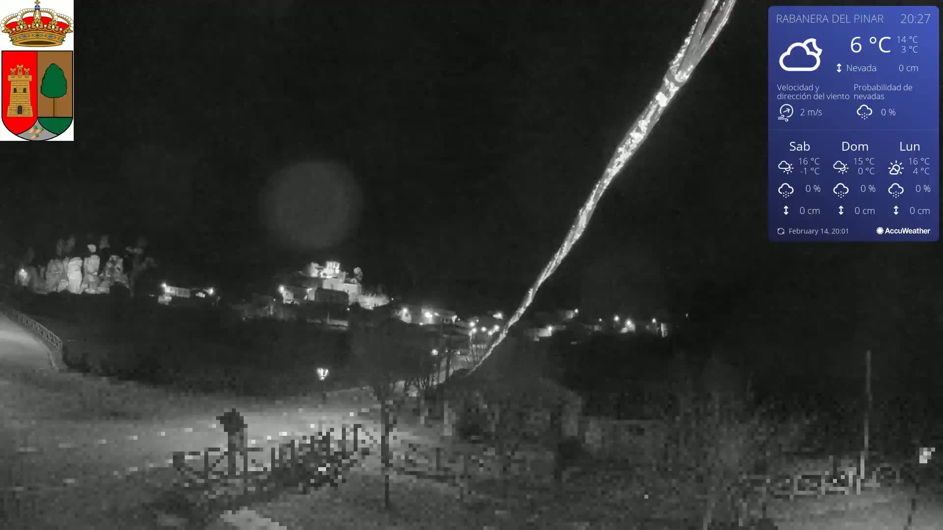 A nighttime, low-light view of a small town illuminated with streetlights, under a partly cloudy sky with a temperature of 6°C.