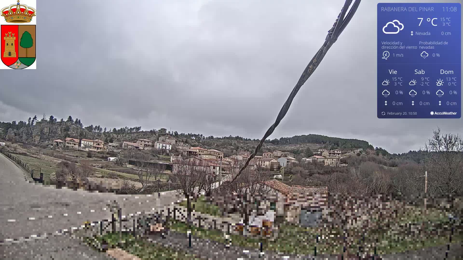 A small village nestled in a hilly landscape under an overcast sky.