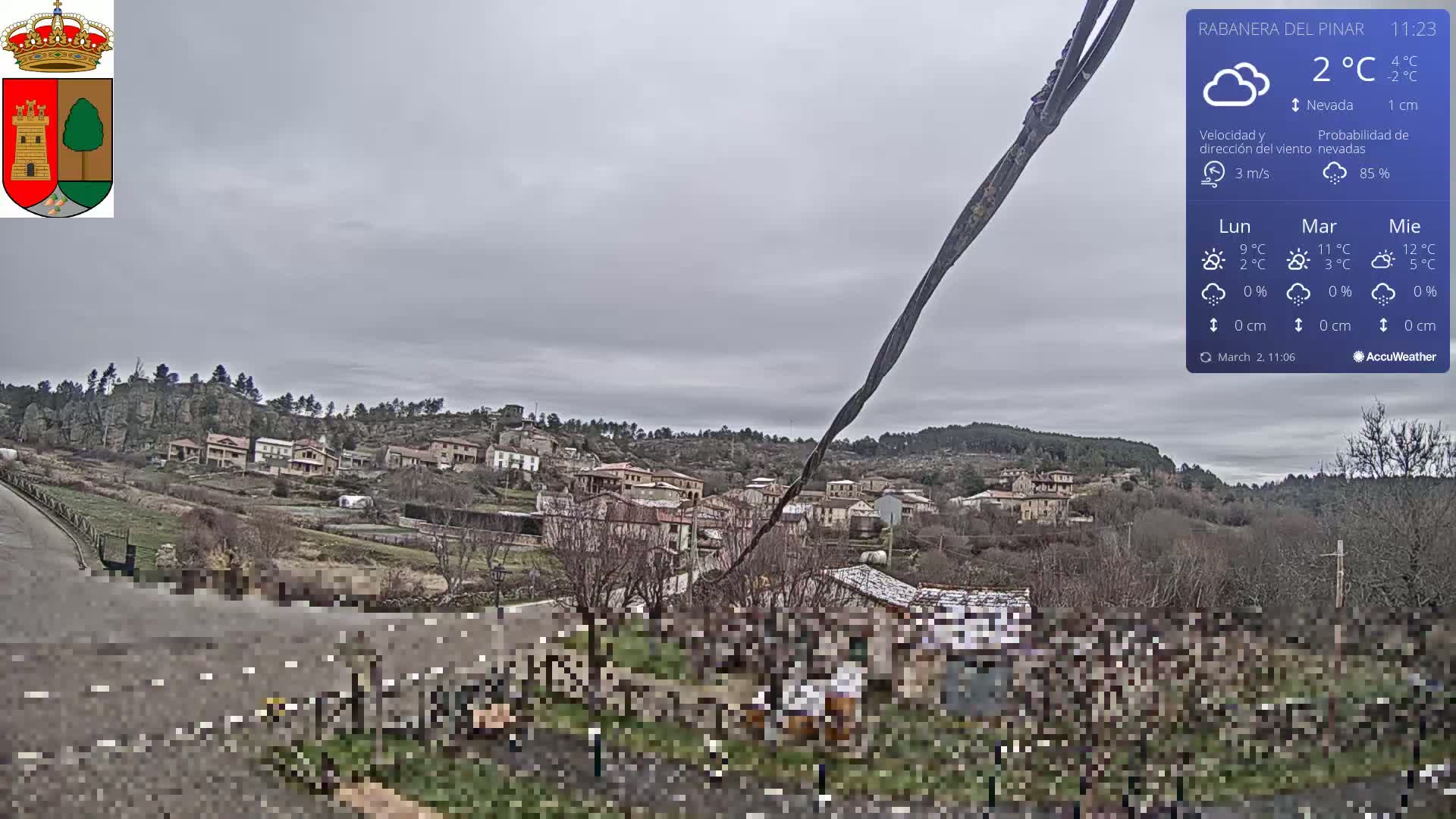 A small village nestled in a hilly landscape under an overcast sky.