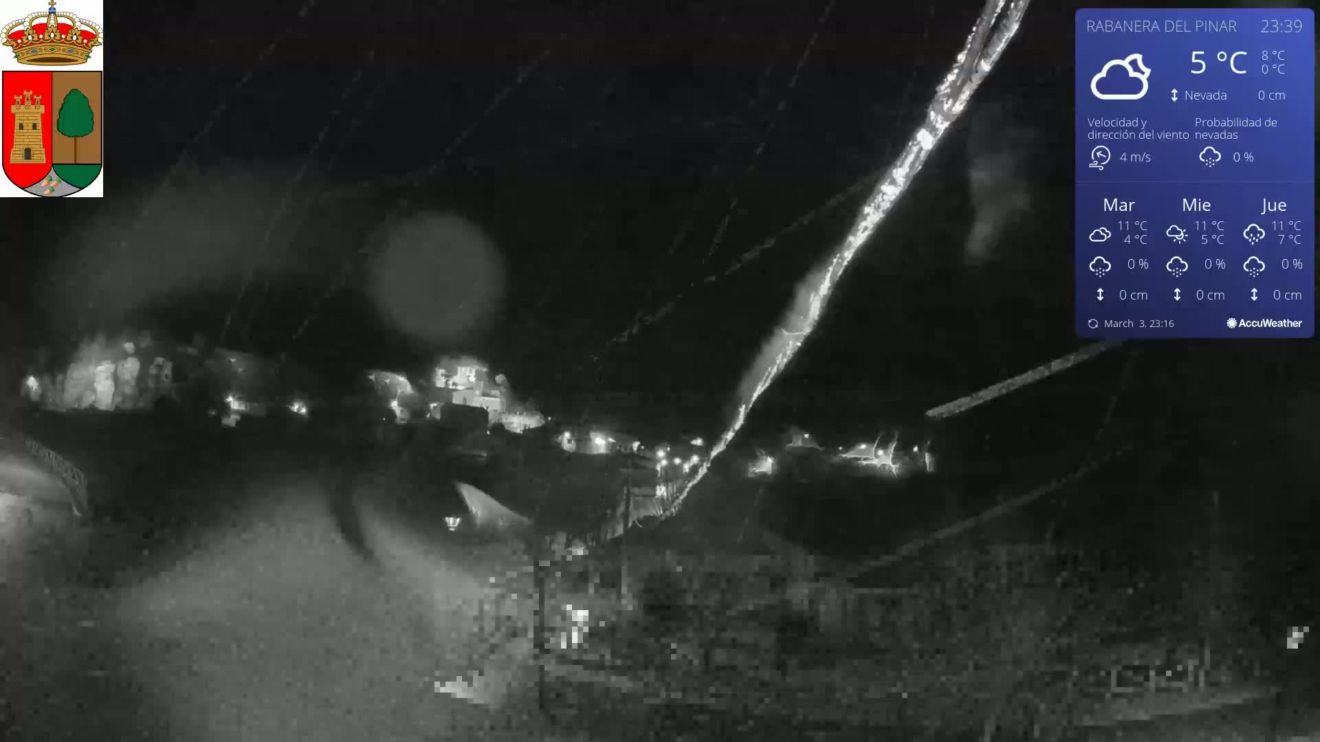 A nighttime, low-light view of a village under rainy conditions.