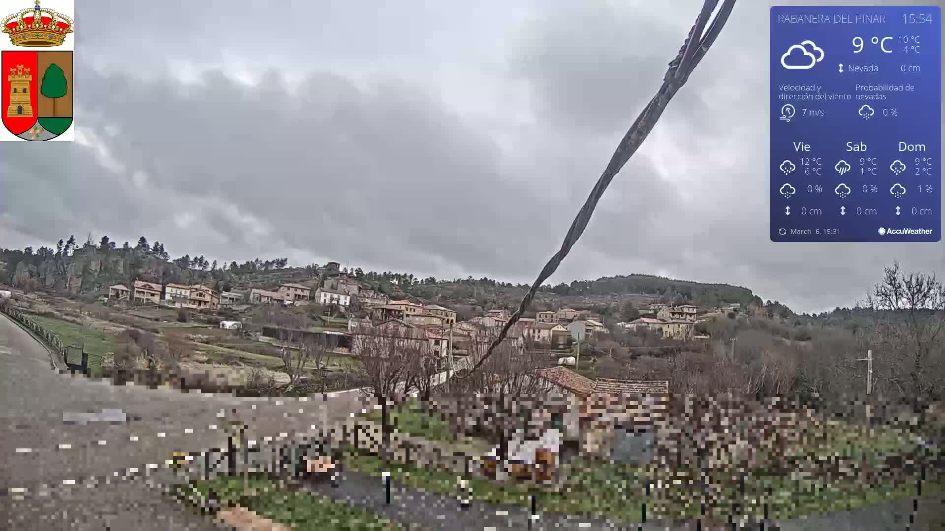 A small village nestled on a hillside under an overcast sky.