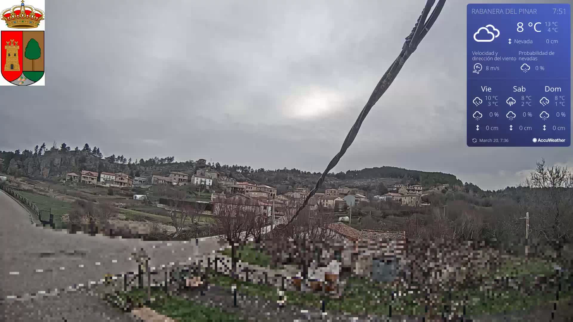 A small village nestled in a hillside is viewed on an overcast day with a light wind.
