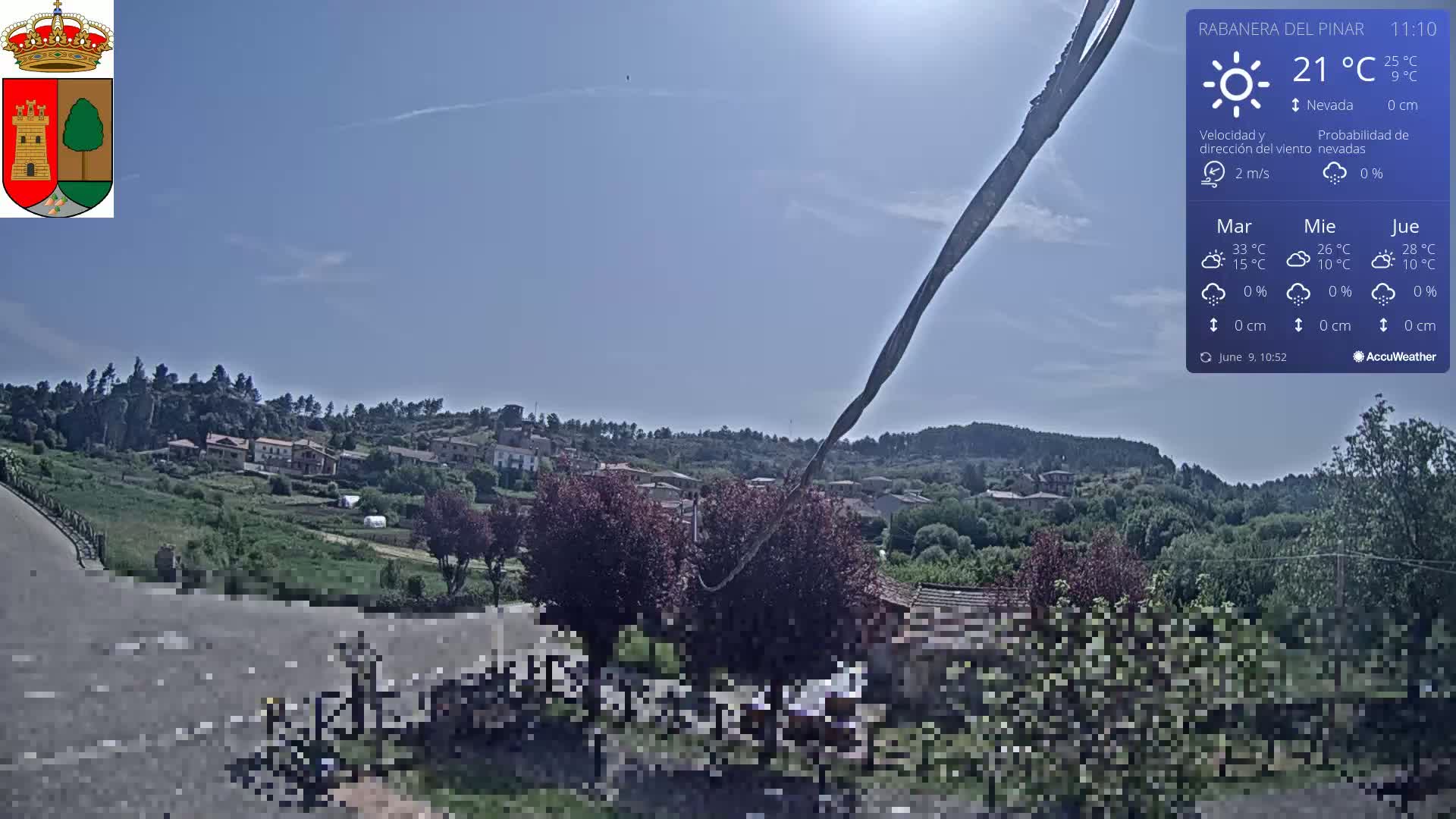 A sunny, clear day overlooks a small village nestled in a verdant hillside.