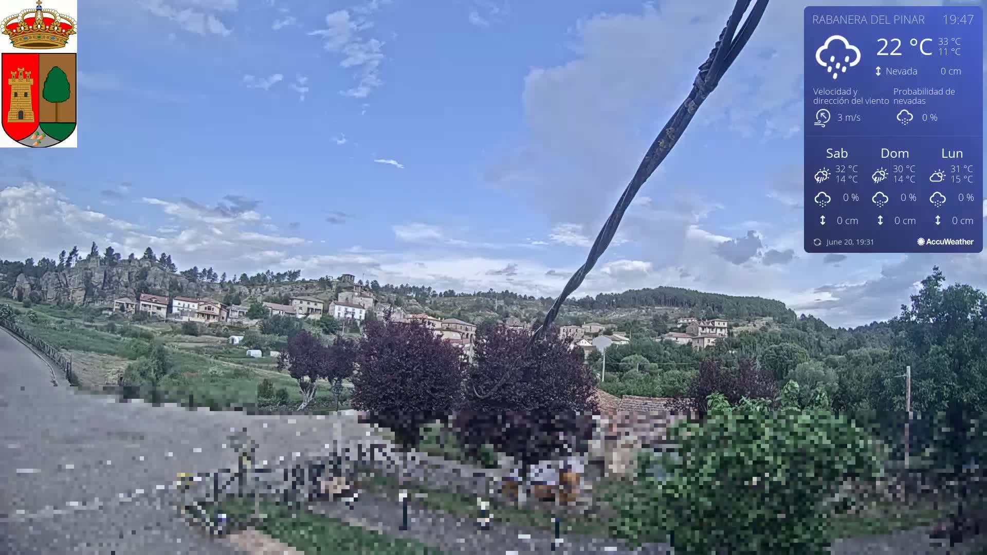 A partly cloudy sky hangs over a small town nestled in a green valley, with a few people visible in the foreground.