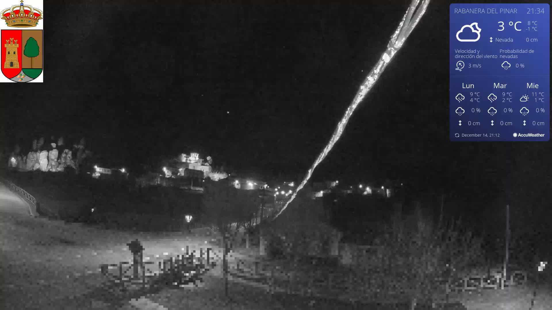 A partially cloudy sky overlooks a hillside village with scattered buildings and mostly barren trees, while a heavily pixelated foreground obscures a curving road.