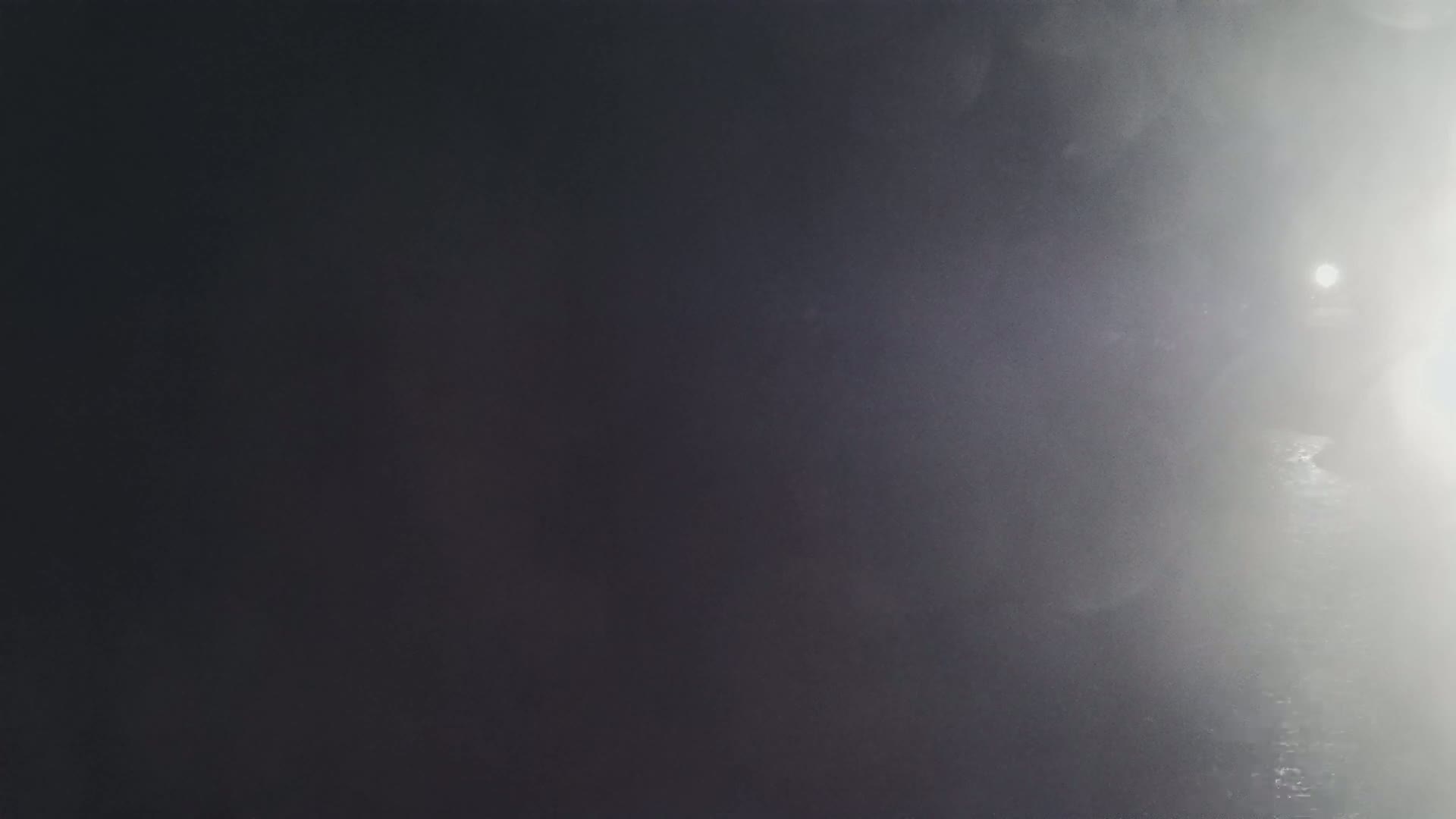 A bright light shines through a dense fog or mist.
