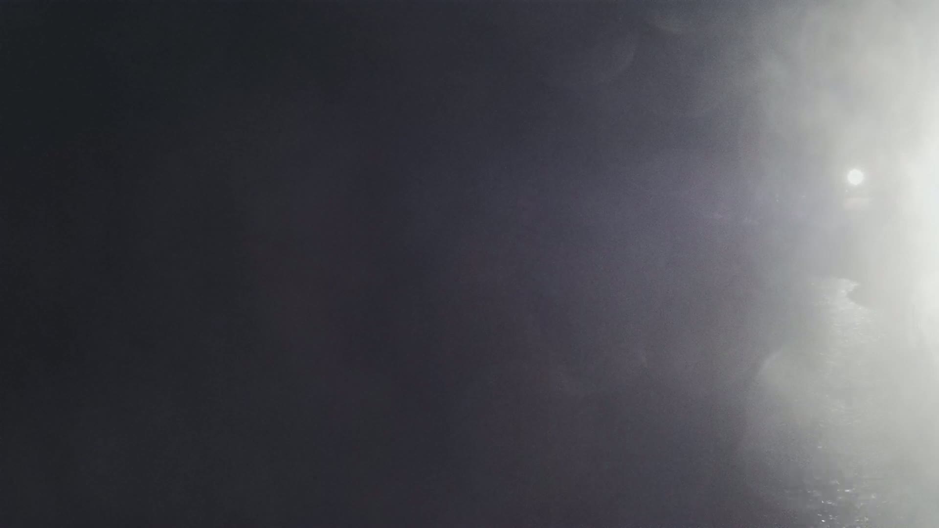 A bright light shines through a hazy, dark gray atmosphere.