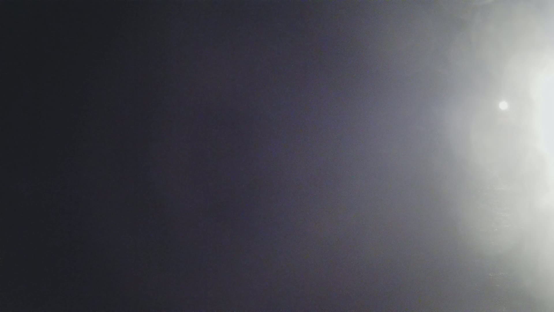 A hazy, bright light shines from the right side of a dark, blurry image.