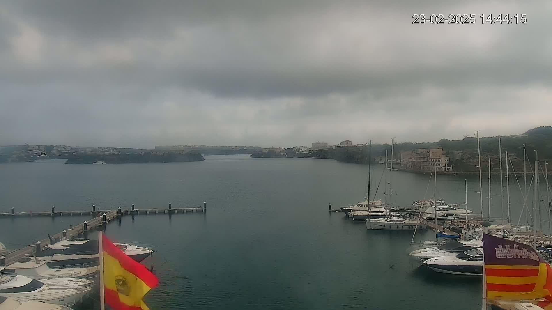 A harbor filled with yachts and sailboats under a cloudy, overcast sky.