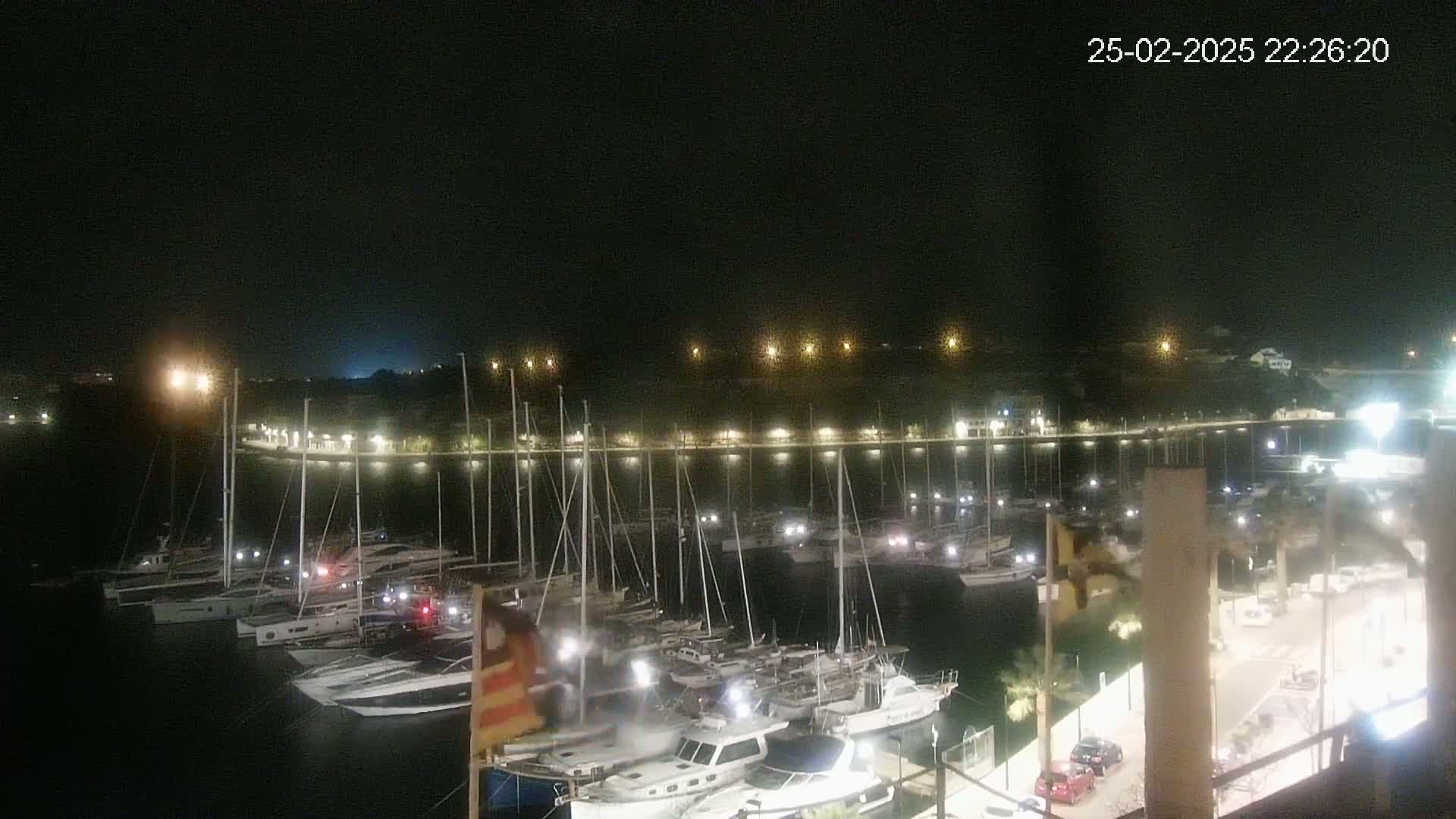 A nighttime view of a marina filled with docked boats under a clear, dark sky.