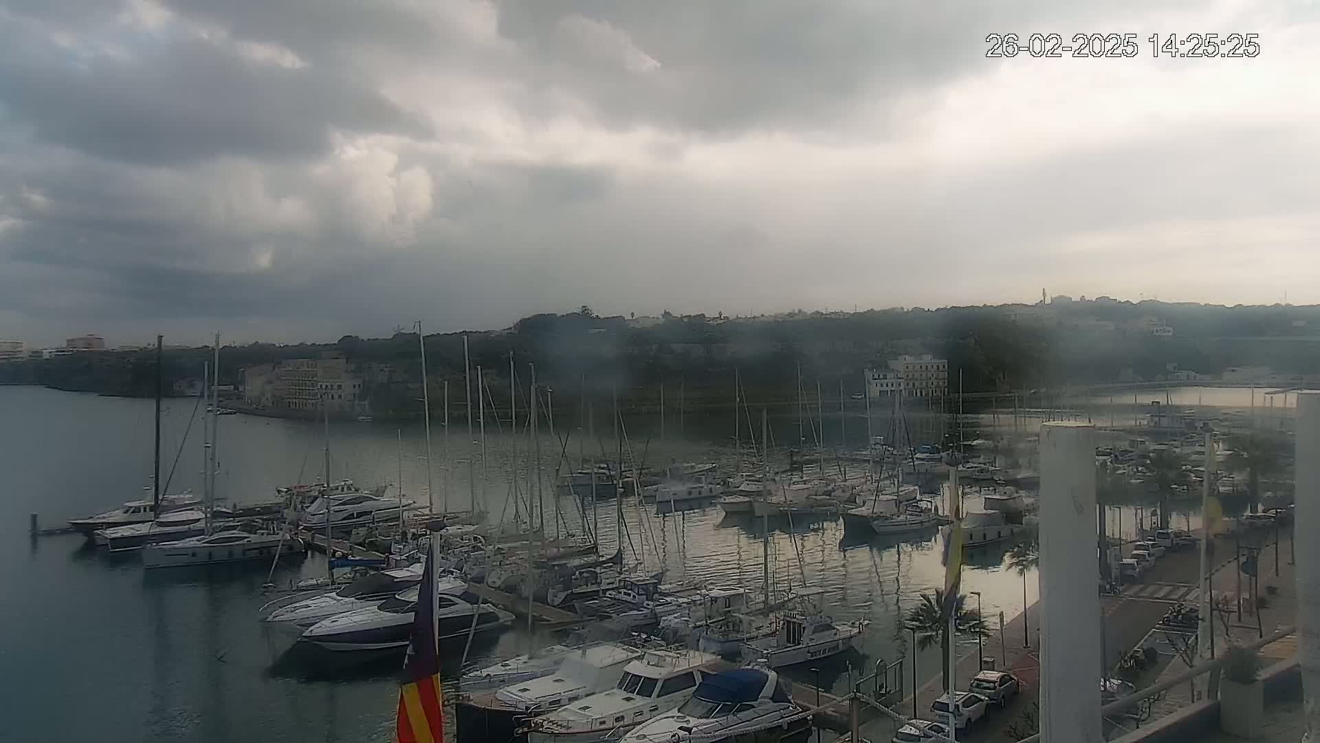 A marina filled with numerous boats and yachts under a cloudy sky.