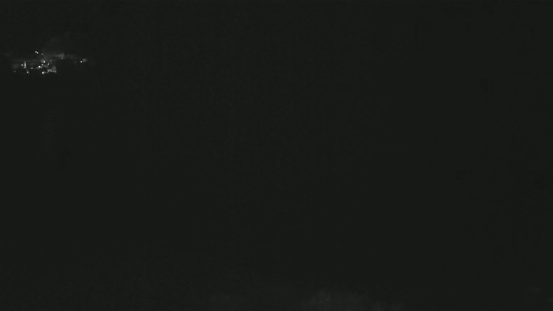 A distant cluster of faint lights is visible in the dark night sky.