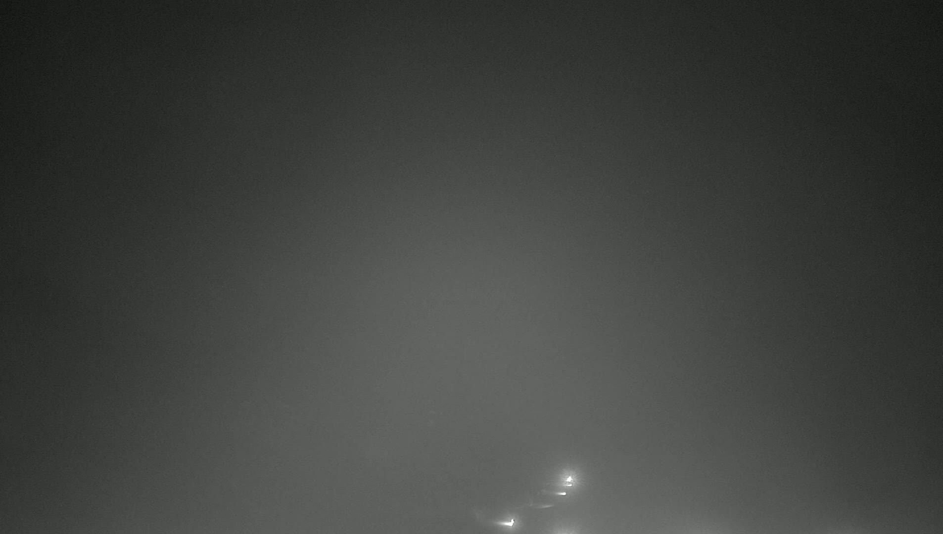 Faint lights are visible in the distance through a thick fog.