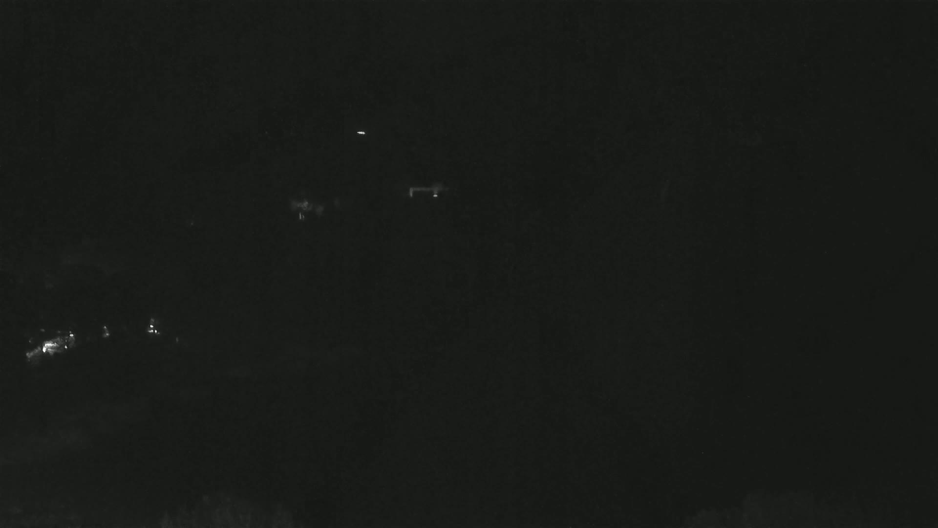 Faint lights are visible in the dark nighttime landscape.