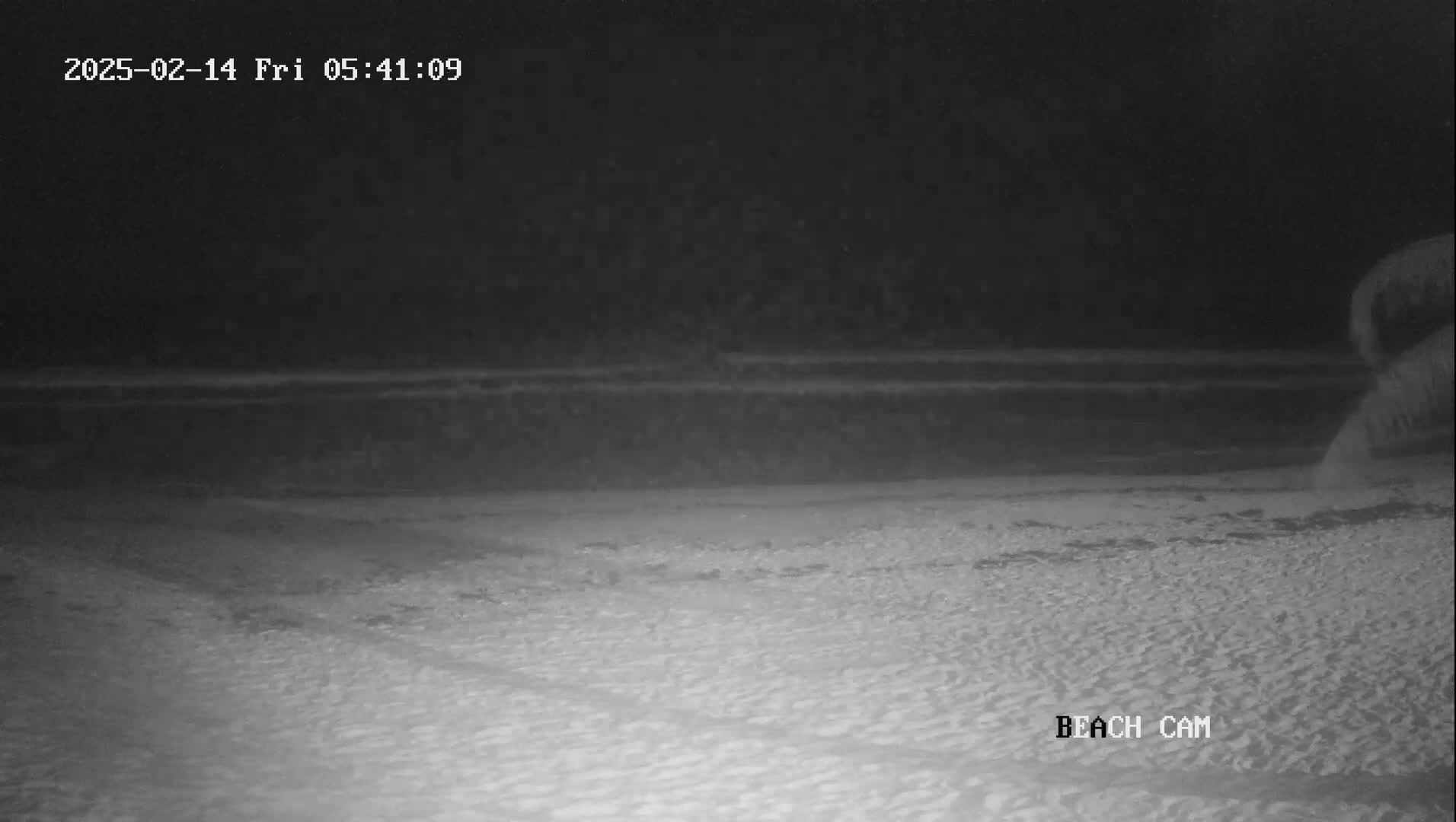 A snow-covered beach is visible at night under a dark sky.