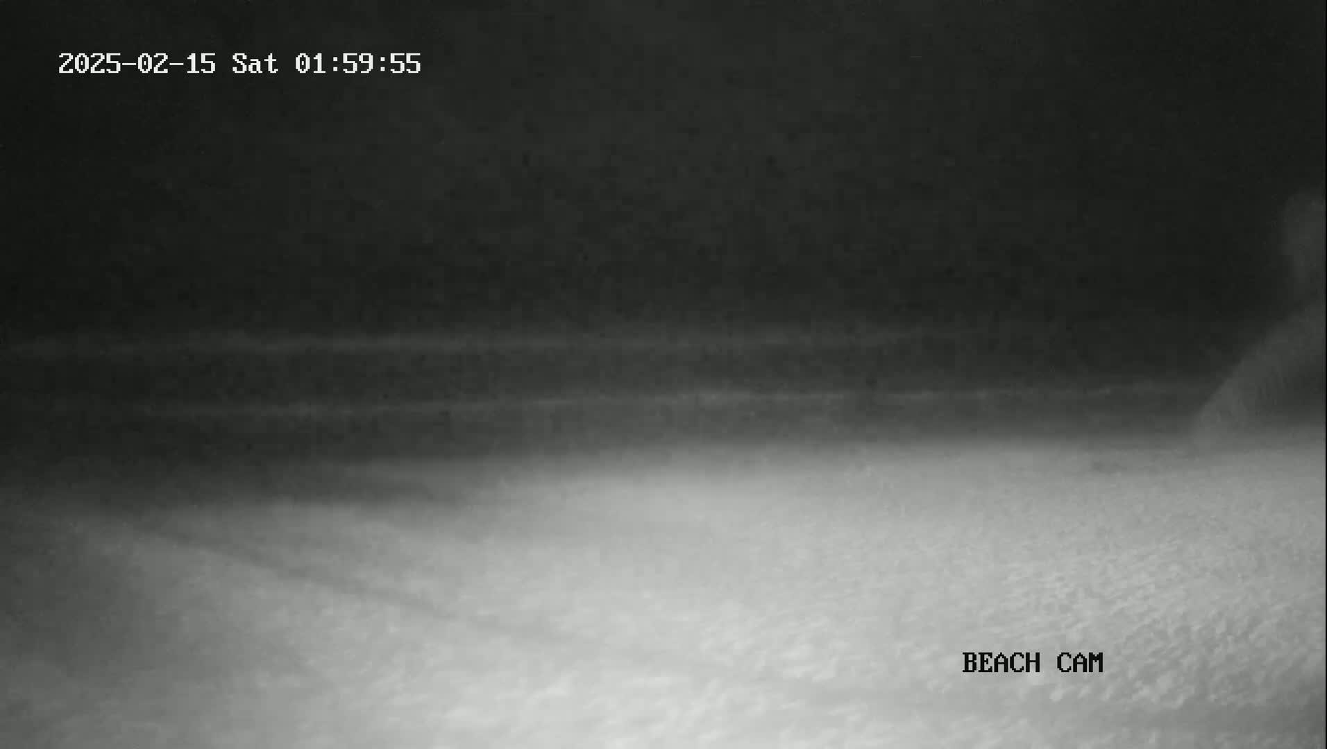A nighttime beach scene shows a dark, overcast sky and a dimly lit sandy shore.