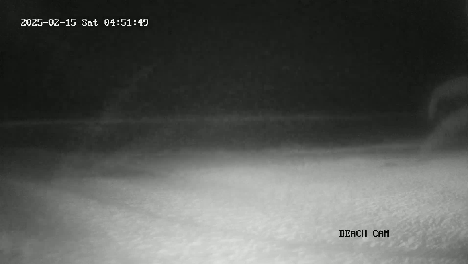 A nighttime beach scene is shown with dark, hazy conditions.
