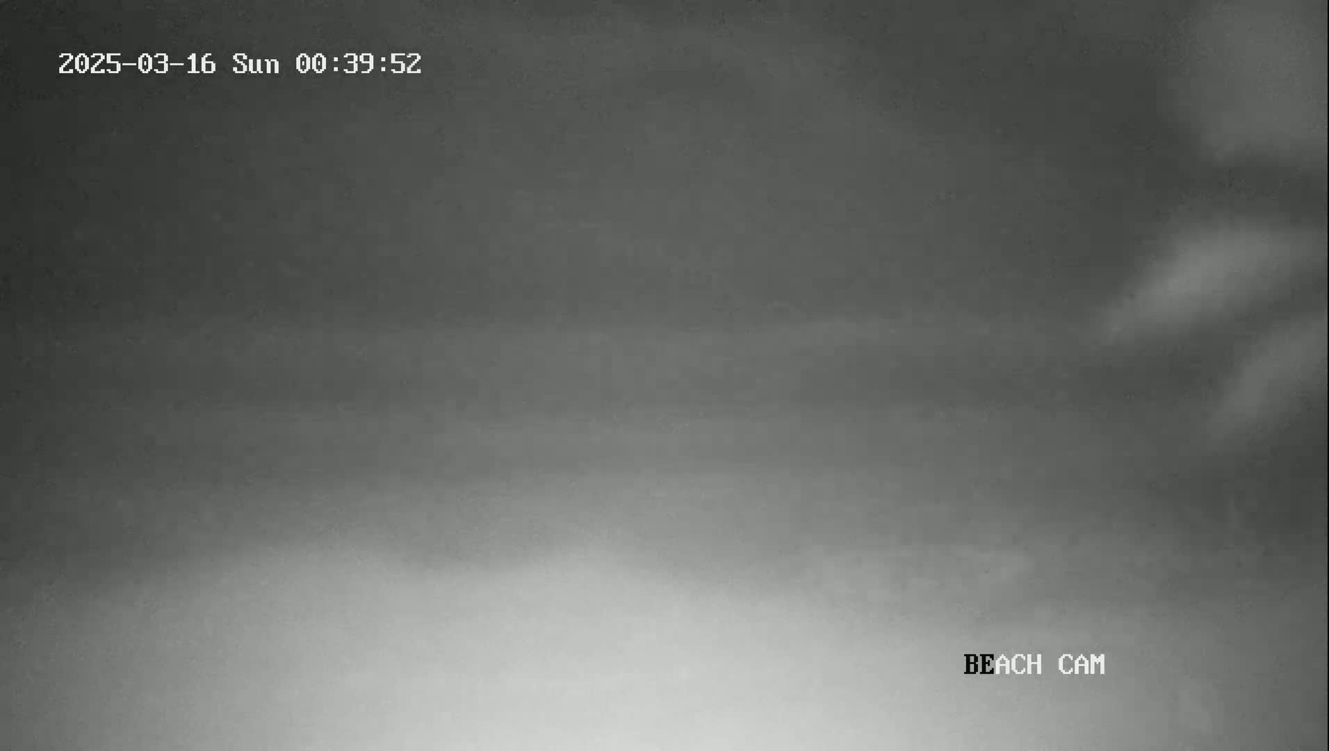 A nighttime beach scene is shown with an overcast sky.
