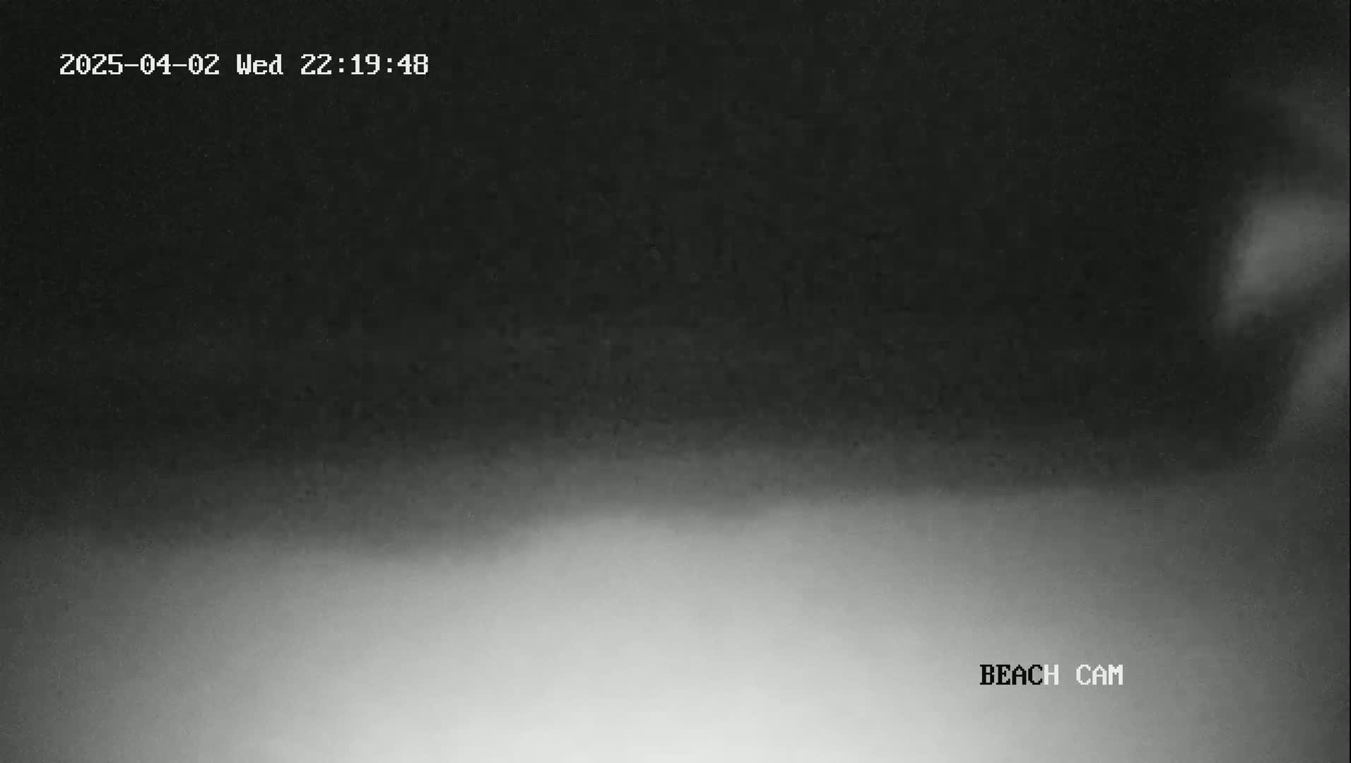 A low-light, grayscale image shows a dark sky gradually lightening towards a brighter, hazy bottom.