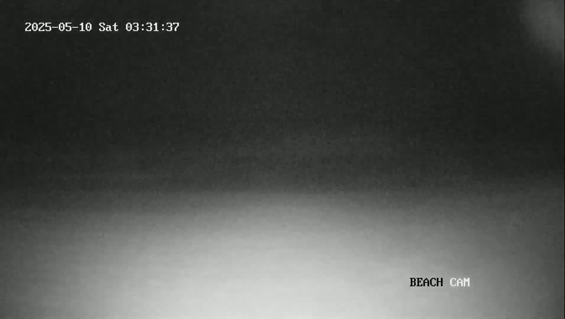 A low-light, grayscale image shows a dark sky gradually brightening to a lighter gray at the bottom.