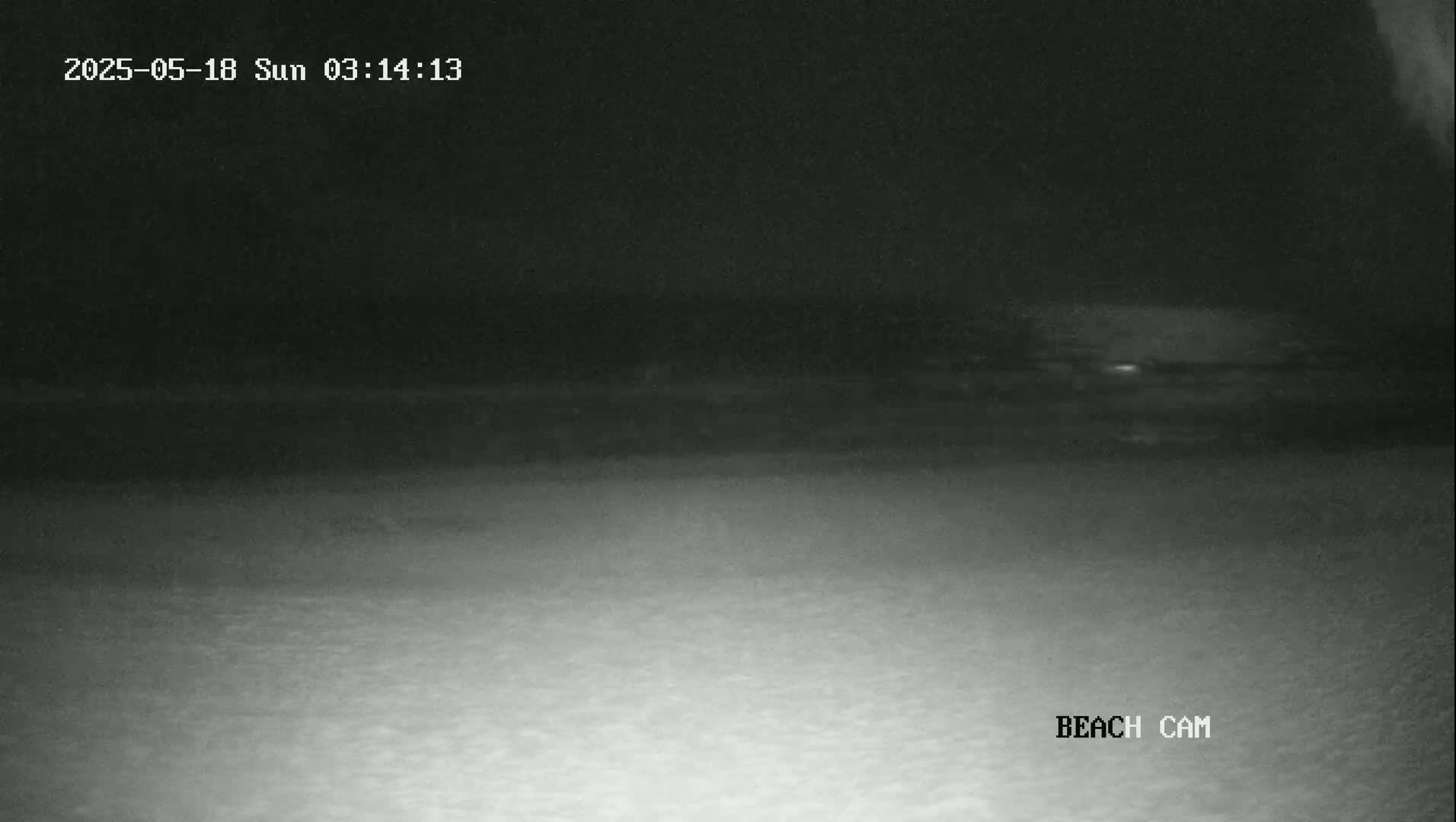 A nighttime beach scene is shown with a dark sky and a lighter-colored beach in the foreground.