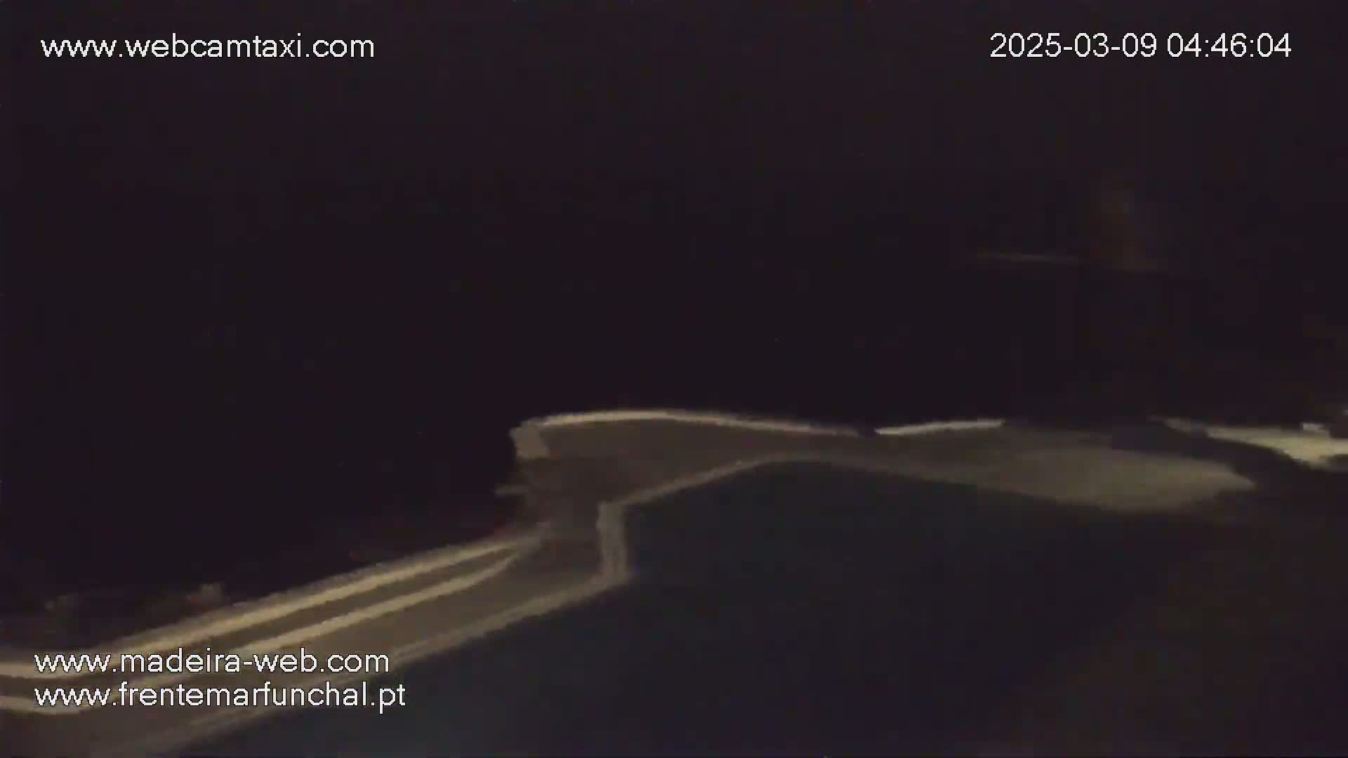 A dark, nighttime image shows a portion of a pool's edge and surface.