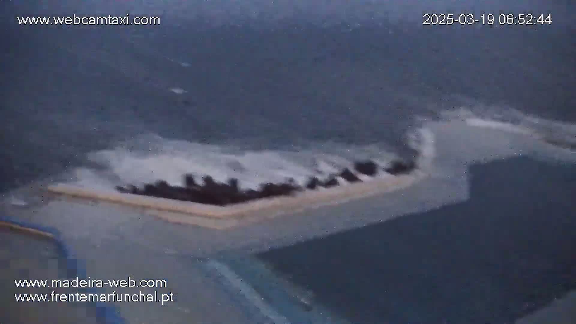 A dark-colored vessel is partially submerged in choppy, dark water.
