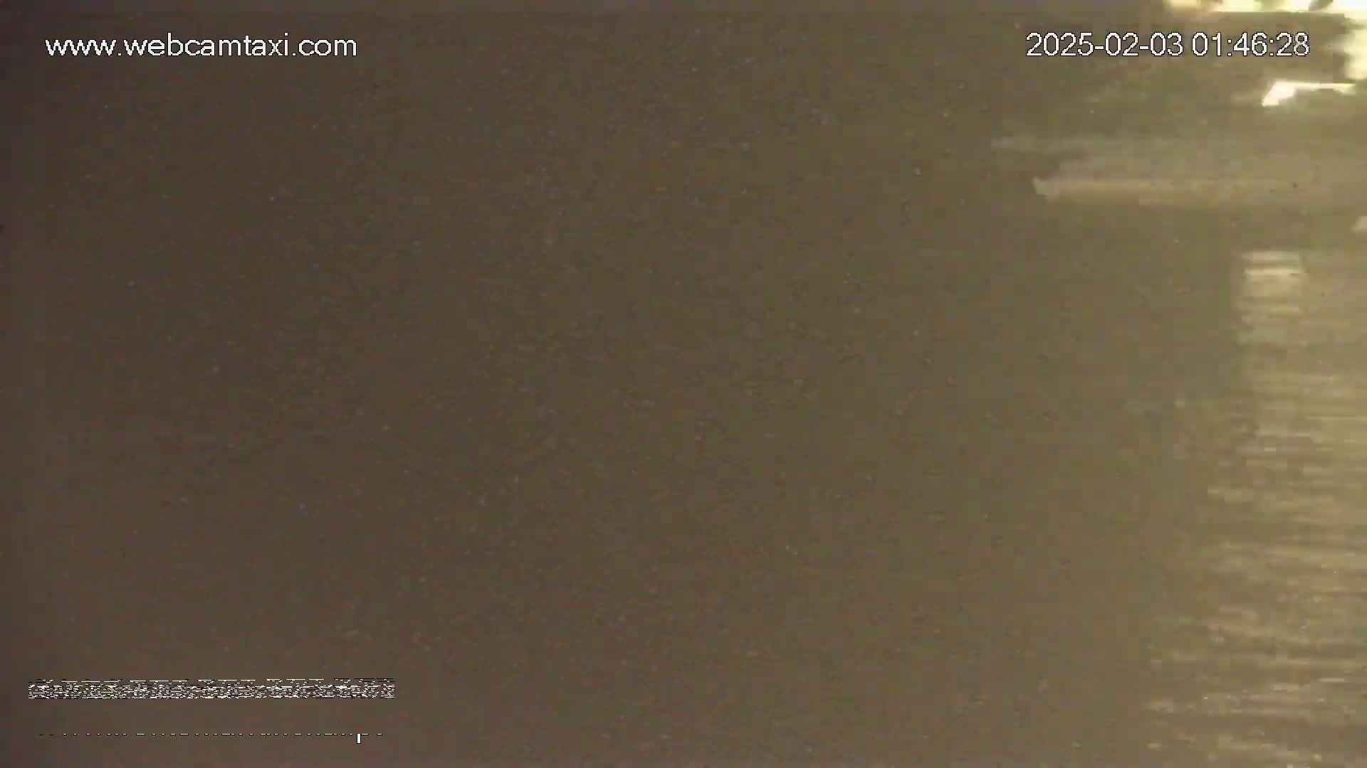 A blurry, dark brown image shows a body of water with subtle ripples on its surface.