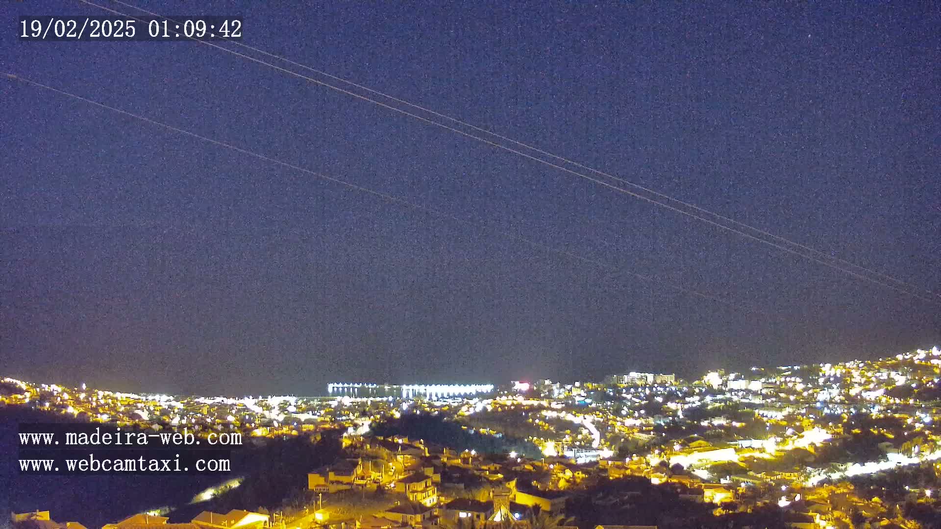 A nighttime, long-range view of a city illuminated with lights under a clear, dark sky.