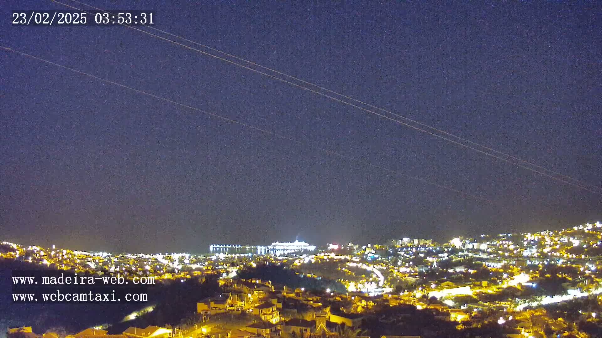 A nighttime view of a city illuminated by lights under a clear, dark sky.